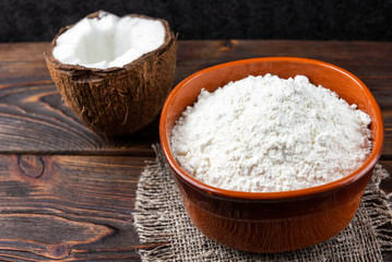 Fototapeta na wymiar Coconut flour on dark wooden background.