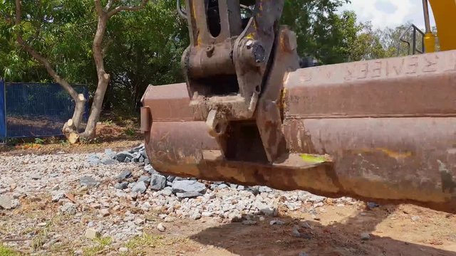 A large excavator moving quarry material on a construction site