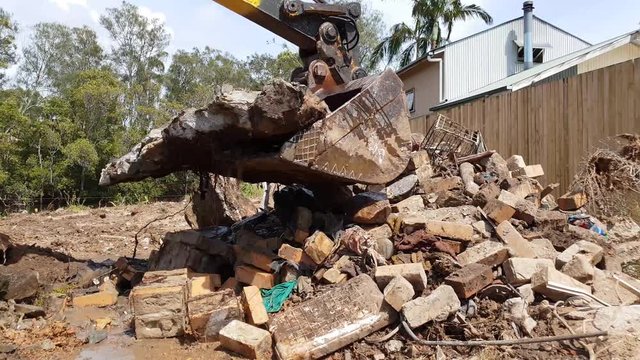 A large excavator moving building materials on a building site