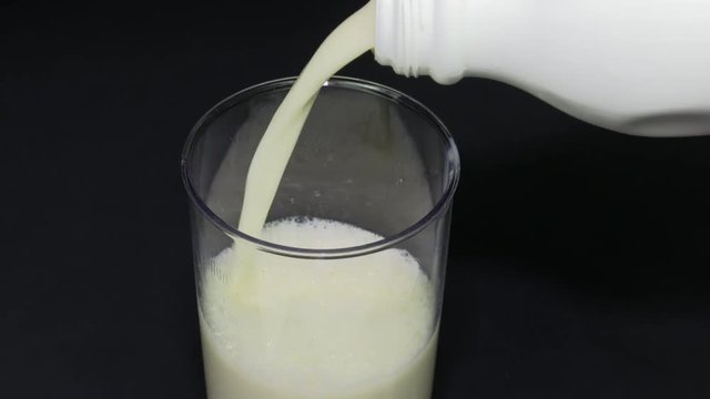 Closeup pouring milk into a measuring cup making it easy to use in a pastry or menu.