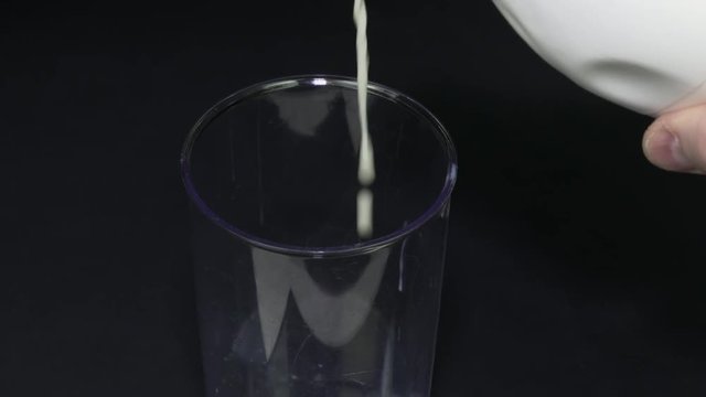 Closeup pouring milk into a measuring cup making it easy to use in a pastry or menu.