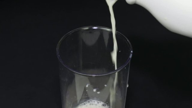 Closeup pouring milk into a measuring cup making it easy to use in a pastry or menu.
