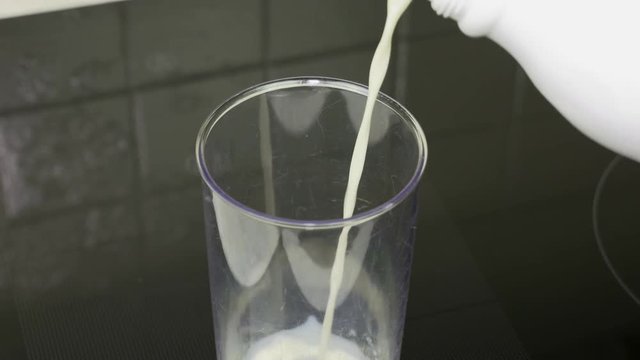 Closeup pouring milk into a measuring cup making it easy to use in a pastry or menu.