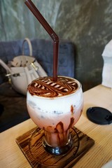 Close up of chocolate frappe coffee with whipped cream on wooden table, frappuccino, Selective focus, Vertical