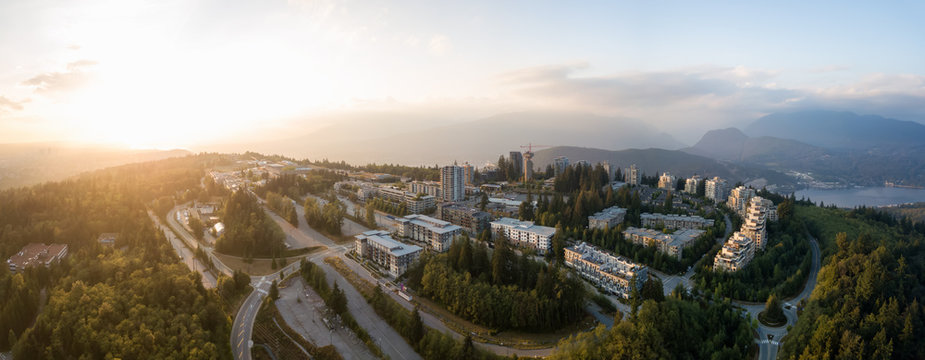 Aerial view of residential buildings on top of Burnaby Mountain during a vibrant sunset. Taken in Greater Vancouver, BC, Canada.