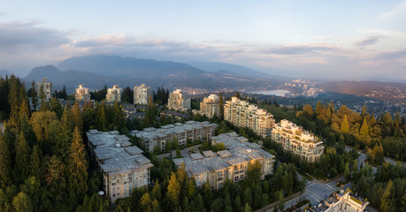 Aerial view of residential buildings on top of Burnaby Mountain during a vibrant sunset. Taken in Greater Vancouver, BC, Canada.