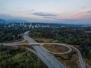 Aerial view of a highway entrance and exit in the modern city during a vibrant summer sunset. Taken in Burnaby, Greater Vancouver, BC, Canada.