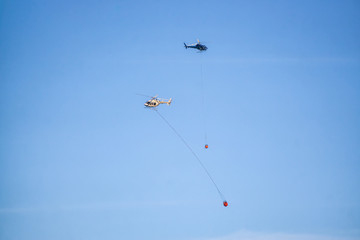 Helicopter fighting BC forest fires during a hot sunny summer day. Taken near Port Alice, Northern Vancouver Island, British Columbia, Canada.