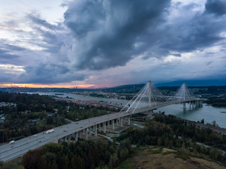 Aerial view of Trans Canada Highway near the Port Mann Bridge during a dramatic cloudy sunset. Taken in Surrey, Vancouver, BC, Canada.