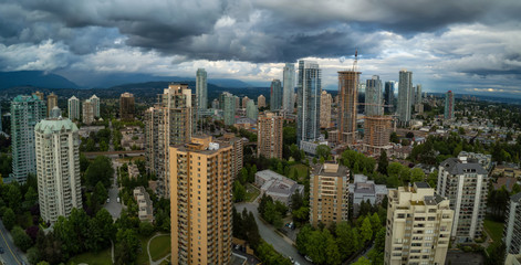 Fototapeta premium Aerial Panoramic view of residential homes in a modern city during a vibrant summer cloudy day. Taken in Burnaby, Vancouver, BC, Canada.