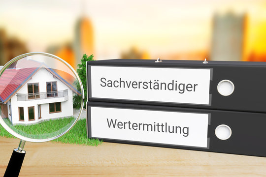 Wert einer Immobilie. Ordner beschriftet mit den W&ouml;rtern Sachverst&auml;ndiger und Wertermittlung liegen neben einem Haus-Modell mit Lupe auf einem Schreibtisch. Skyline einer Stadt im Hintergrund.