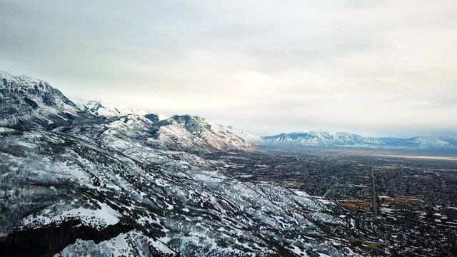 Beautiful winter landscape view of Utah lake, rocky mountains, and a valley below.