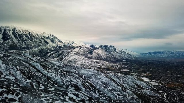 Beautiful winter landscape view of Utah lake, rocky mountains, and a valley below.