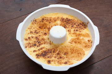 home made vanilla and cinnamon flan over a wooden table