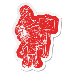 happy cartoon distressed sticker of a man with placard wearing santa hat