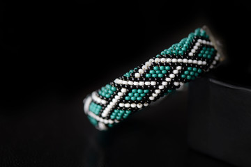 Celtic print emerald color bracelet on a dark background close up
