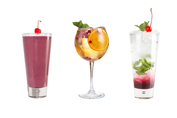A variety of alcoholic drinks, beverages and cocktails on a white background. Three different drinks in glass goblets decorated with berries.