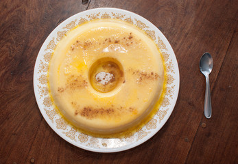 home made vanilla and cinnamon flan over a wooden table