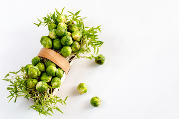 Brussels sprout - vegetable culture. Small fruits in a basket on a wooden background. Soft focus.
