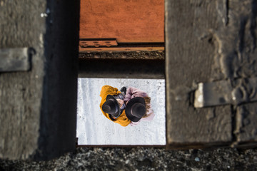guy and girl in black hats kissing under the bridge