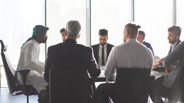 Contractors representatives discuss the construction plan at the official meeting with the construction Customer, top view. Laptop, smartphone and builder's helmet are lying on table