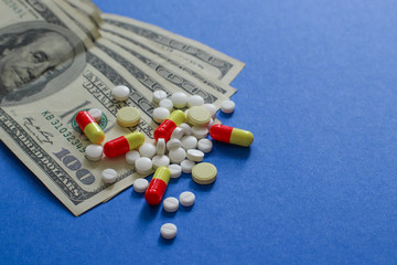 Assorted pharmaceutical medicine pills, tablets and dollars. Healthy life or insurance concept.