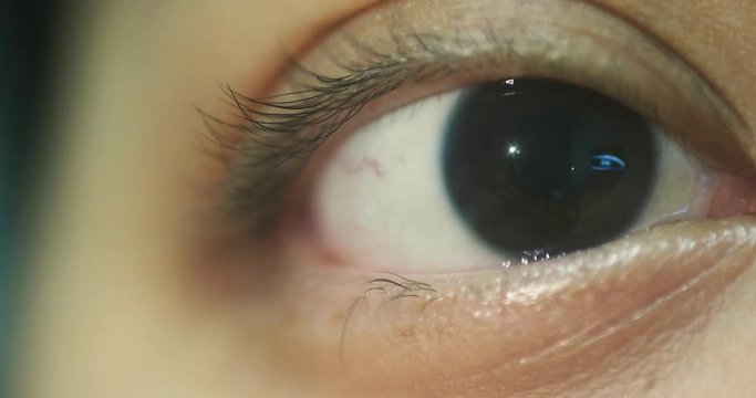 Close Up Macro Shot Of A Adults Eye, With The Reflection Of A TV In The Pupil.