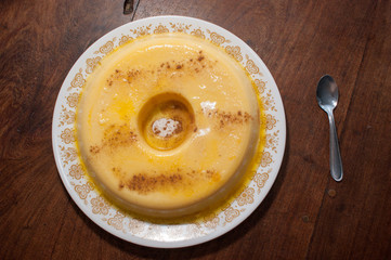 home made vanilla and cinnamon flan over a wooden table