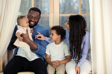 African-American couple with their children at home. Happy parents