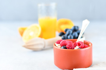 oatmeal with organic blueberries and raspberries, fresh orange juice and grapes. light background, selective focus and copy space, Breakfast concept. diet, healthy food