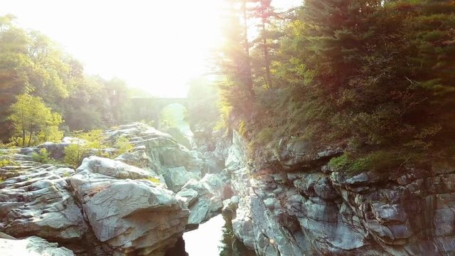 wild mountain river in sun light with bautiful old bridge in the background aerial shot of fresh mountain river in switzerland