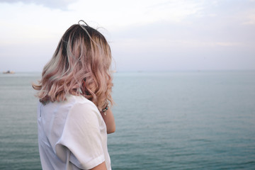beautiful girl with light pink hair against the background of the sea