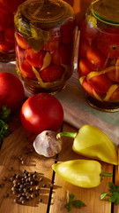 A table with the preservation of red tomatoes with sweet peppers and garlic under the sun - many vitamins by nature.