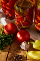 A table with the preservation of red tomatoes with sweet peppers and garlic under the sun - many vitamins by nature.