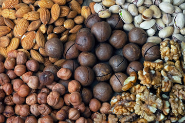 varied assorted nuts on wooden background top view, close-up