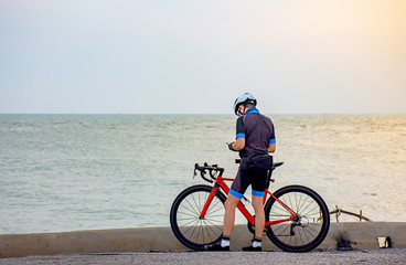 Man and a bicycle parked on the road by the sea In the morning