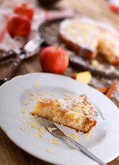 homemade apple pie - a piece of homemade apple pie on a plate with fresh apples and cinnamon sticks on a rustic wooden table