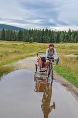 Mountain bikers witch a stroller, bicycle trailer for children, Izerskie Mountains, Góry Izerskie