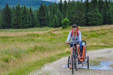 Mountain bikers witch a stroller, bicycle trailer for children, Izerskie Mountains, Góry Izerskie