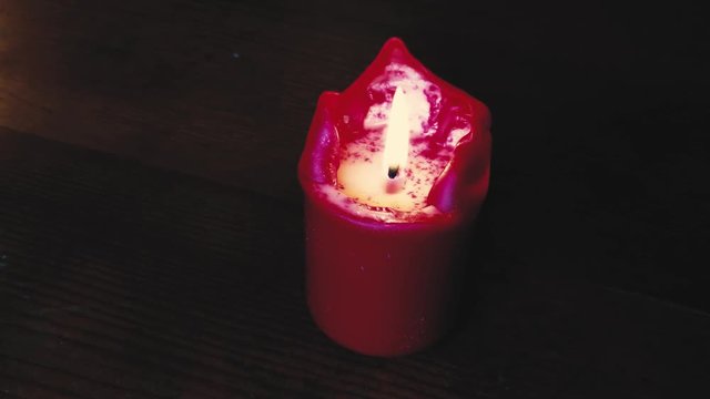 Flickering flame burning candle in dark