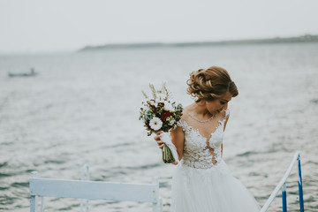 Fototapeta na wymiar Bride with bouquet at beach