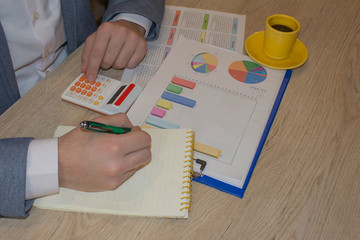 A businessman doing some paperwork using his calculator. Businessperson working
