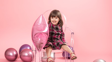 Little girl having fun with balloons and confetti. The concept of celebration and fun.