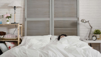 Beautiful young asian woman lying down in bed and sleeping well. tired girl cover body by warm...