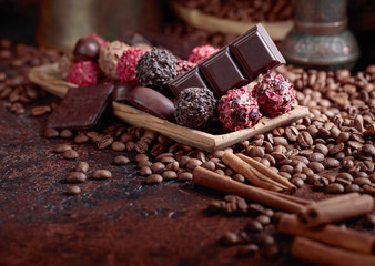 Various chocolates in wooden dish on a brown table.