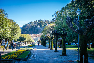 Italy, Bellagio, Lake Como, a group of people in a park