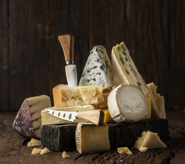 Assortment of different cheese types on wooden background. Cheese background.