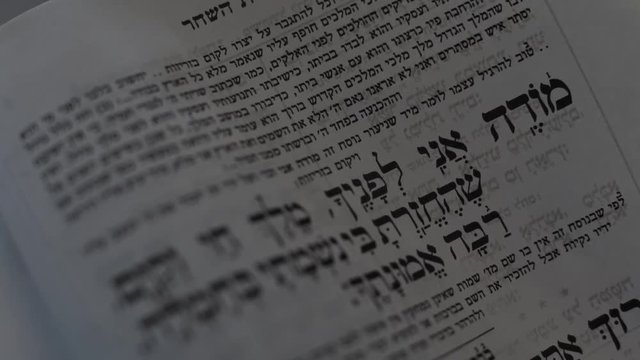 Torah verses Modhe Ani morning prayer. Pray letters from Jewish Torah Bible Old Testament Ancient Text. Spiritual religious text kabbalah close up shot