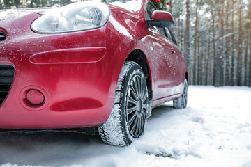 Modern car on snowy road in winter forest. Space for text