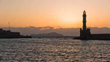 Lighthouse at sunset in the old Venetian harbor, city of Chania, Crete island, Greece
